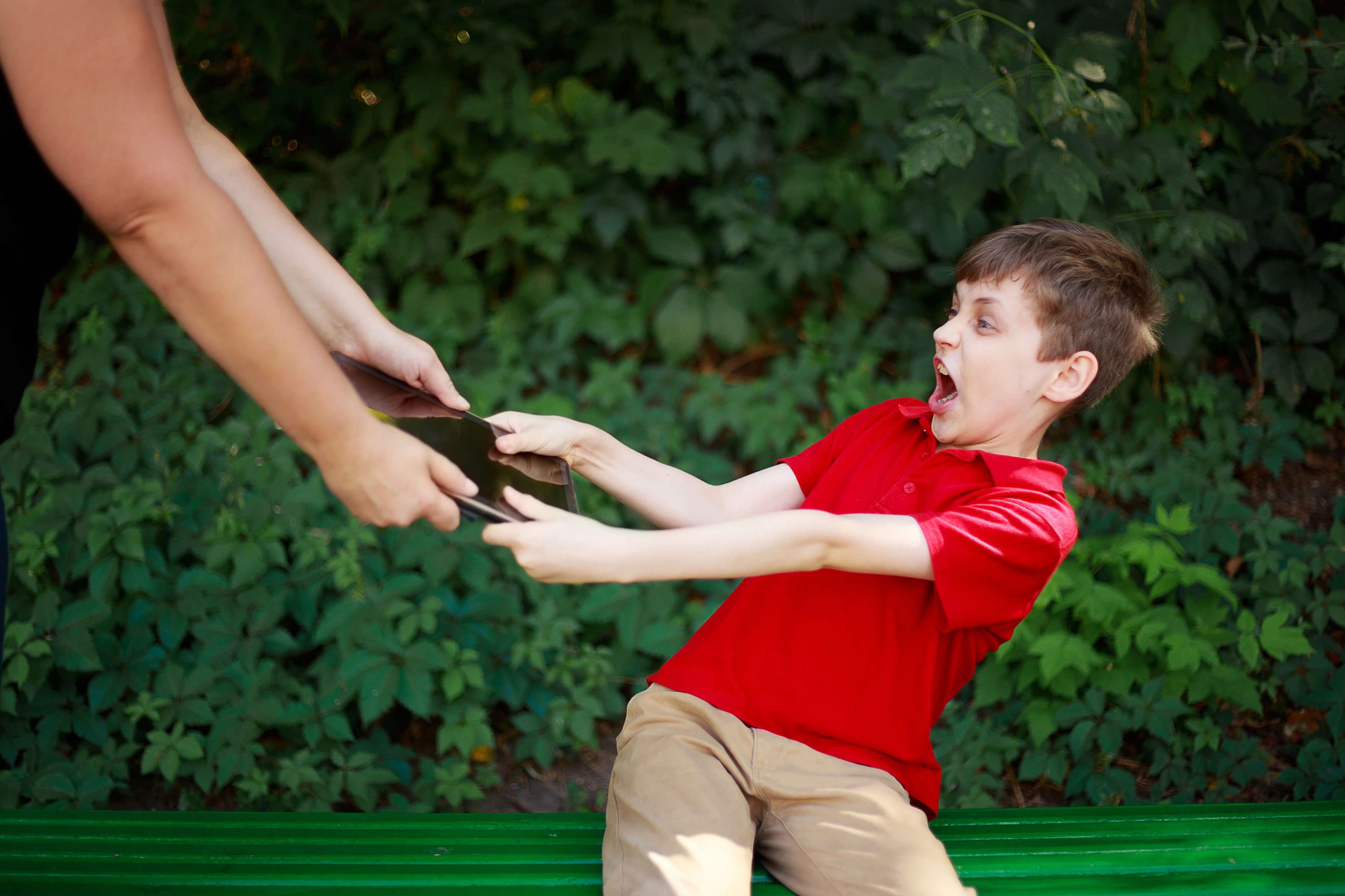 Mother taking tablet away from the addicted child