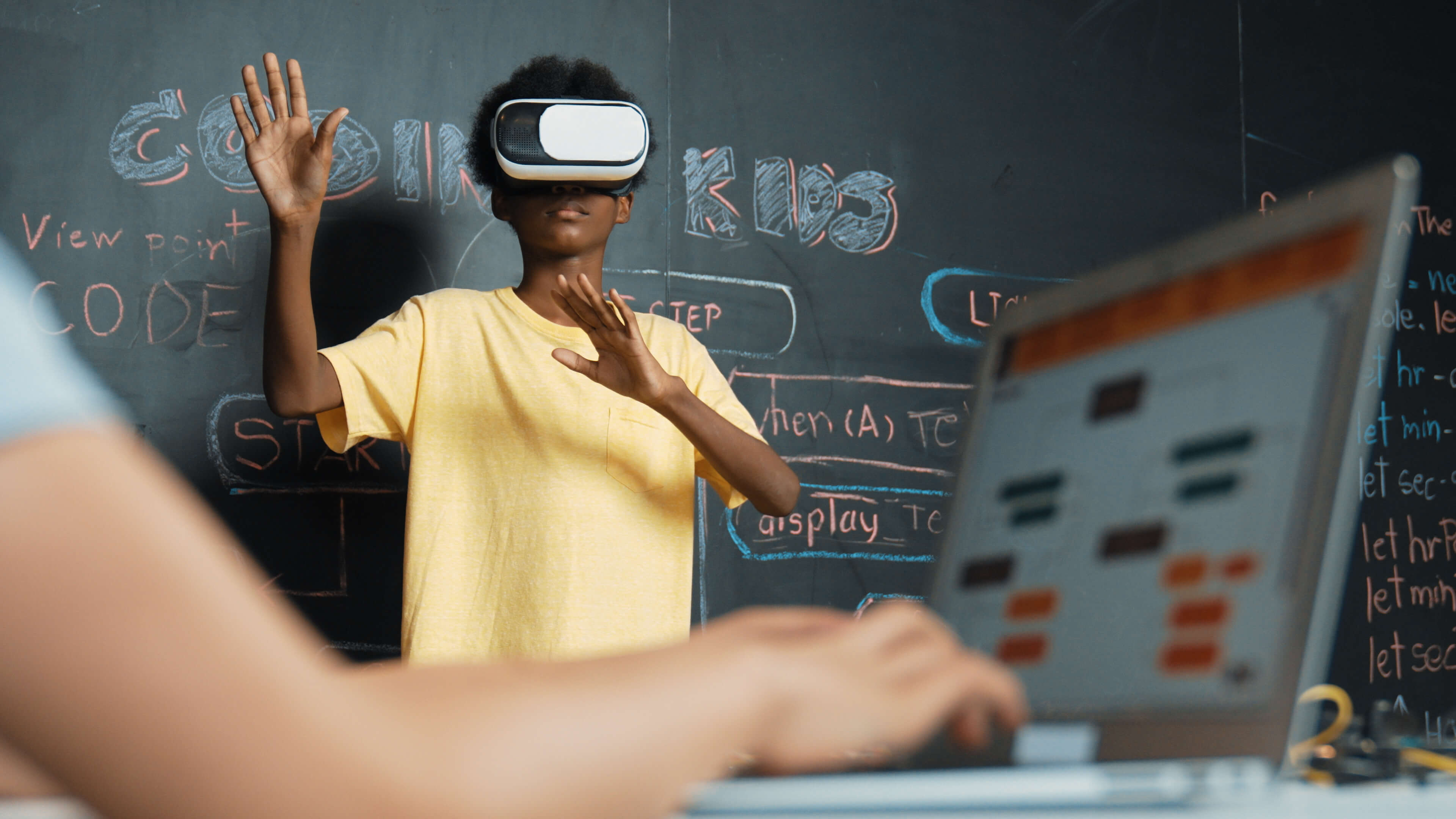 Young boy using VR headset with coding background on board.